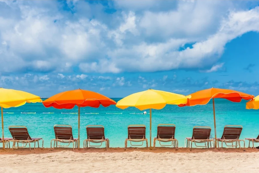 Famiglia in spiaggia con ombrelloni costosi sullo sfondo e calcolatrice in primo piano